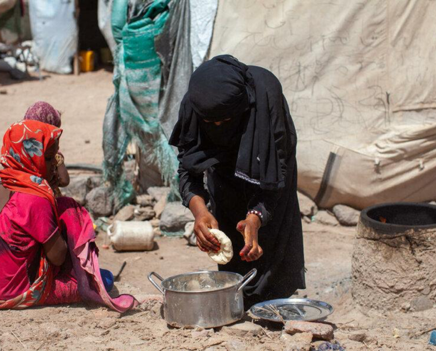 امرأة تنحني فوق قدر.