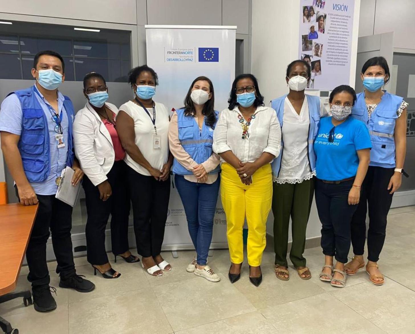En Équateur, huit personnes portant des masques de protection respiratoires posent devant la caméra, côte à côte.