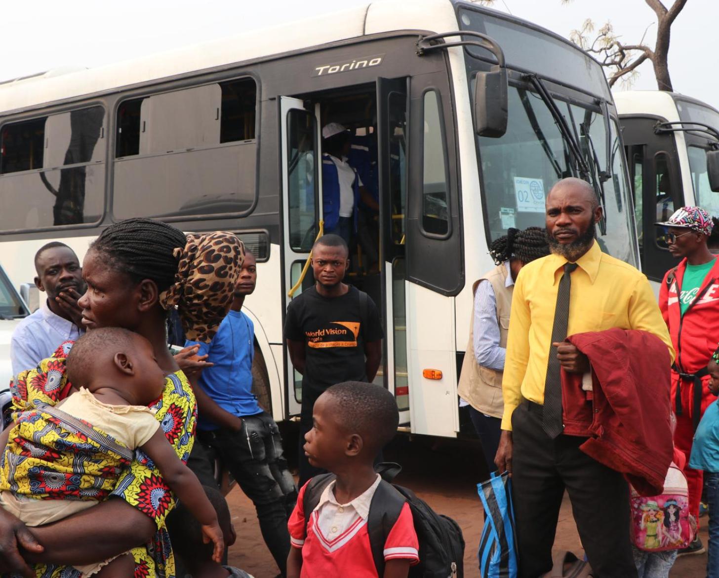 En Angola, des réfugiés, hommes, femmes et enfants arrivent les uns après les autres devant des bus qui les attendent pour les conduire jusqu’à la frontière avec la République démocratique du Congo.