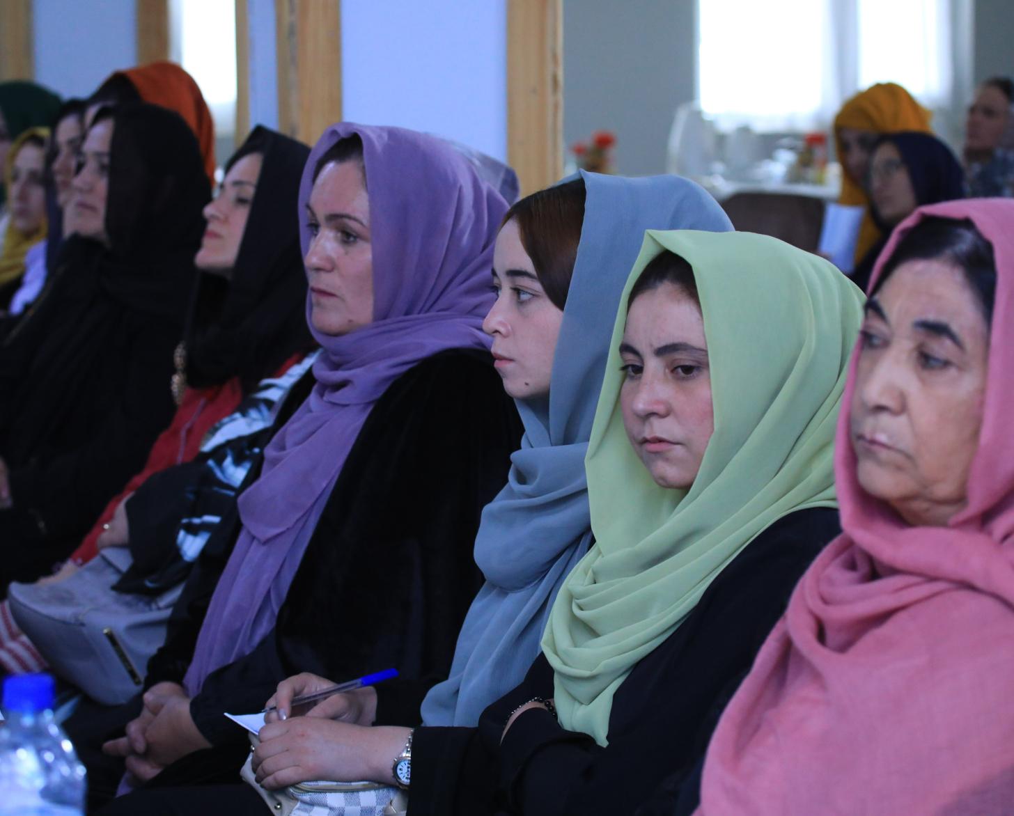 戴着彩色头巾的妇女坐成一排