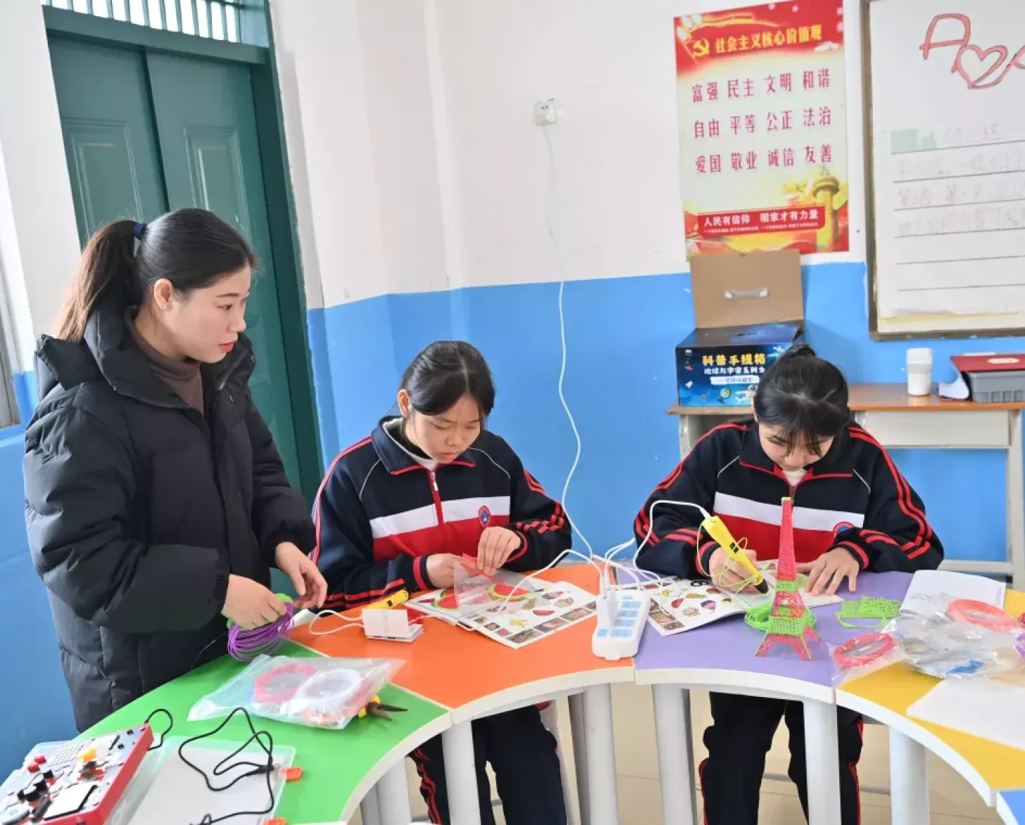 广西天等县仕民实验学校学生许子瑜（中）、农彩杭（右）在老师的指导下制作3D模型（2023年12月27日摄）。
