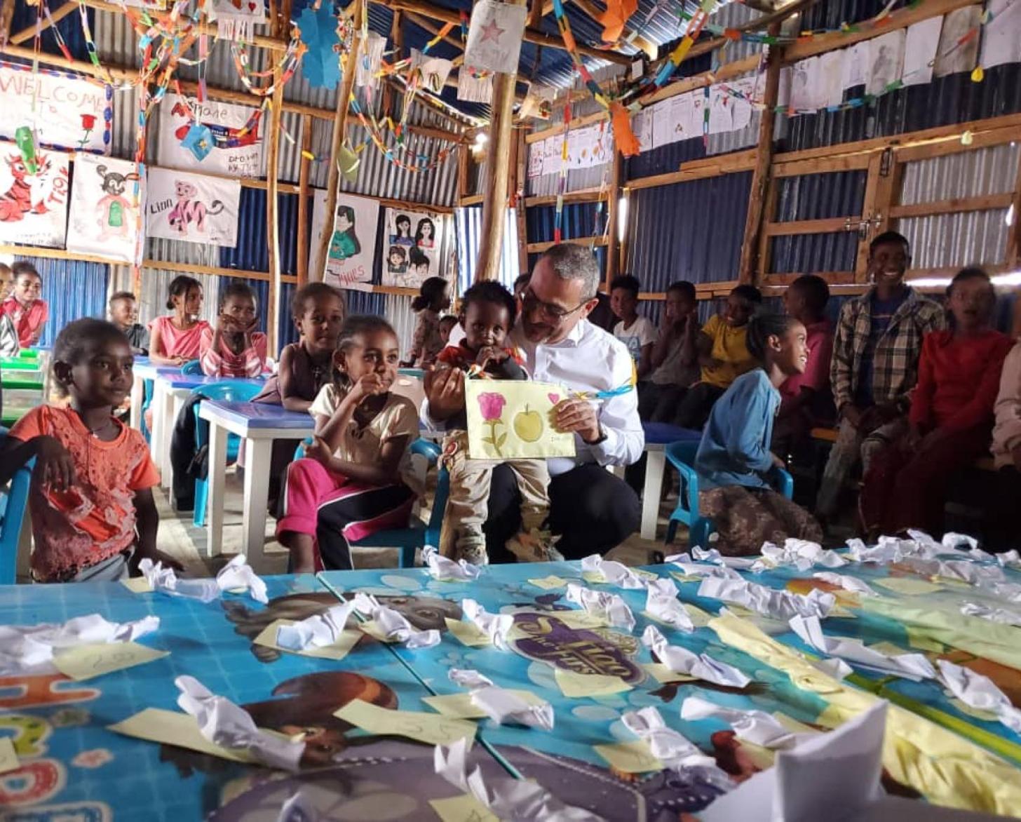 A la izquierda, una persona vestida con ropa tradicional recibe una bolsa de arroz de la CR que está a la derecha, con ropa africana. 