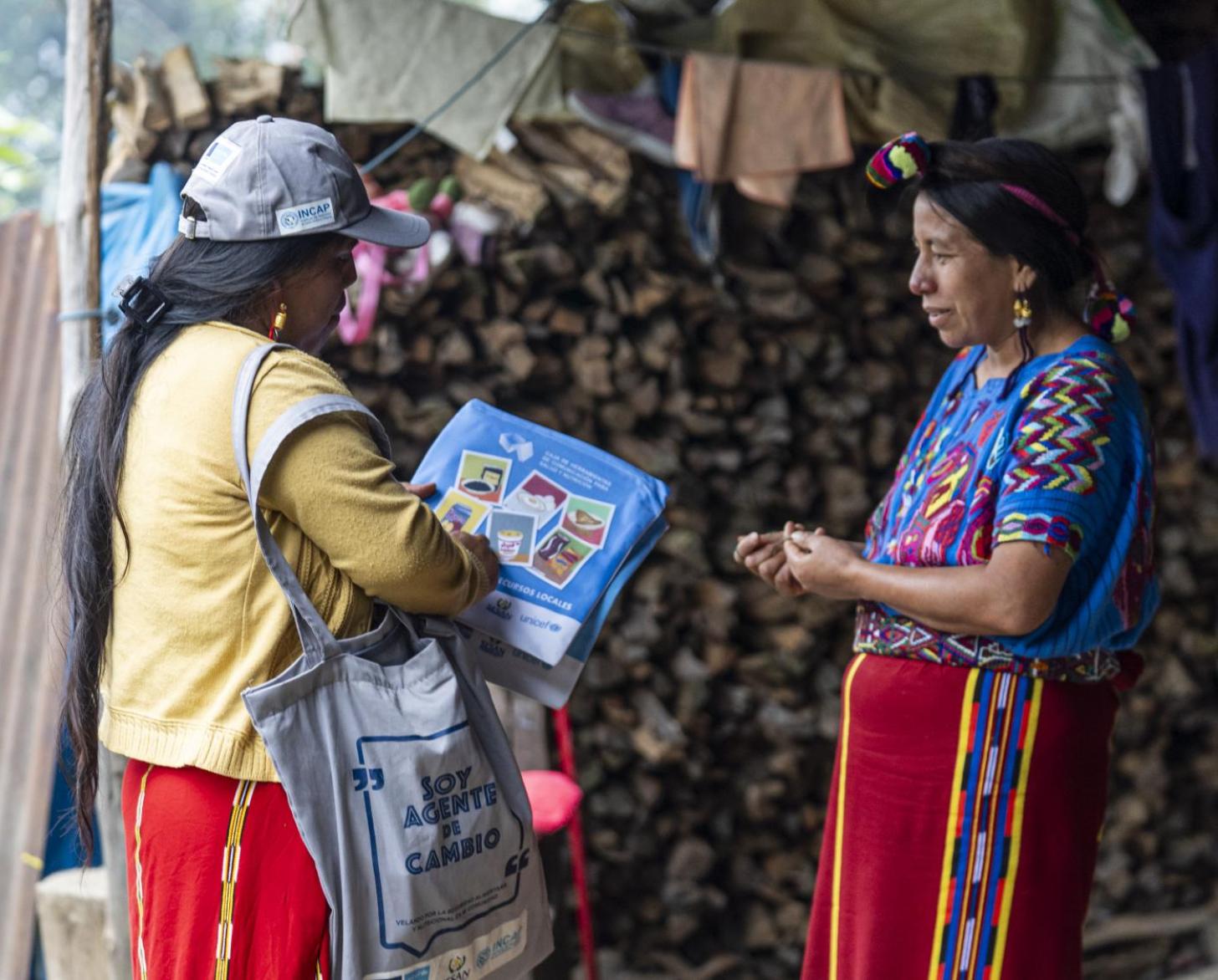 A woman is collecting information from two people outside their home