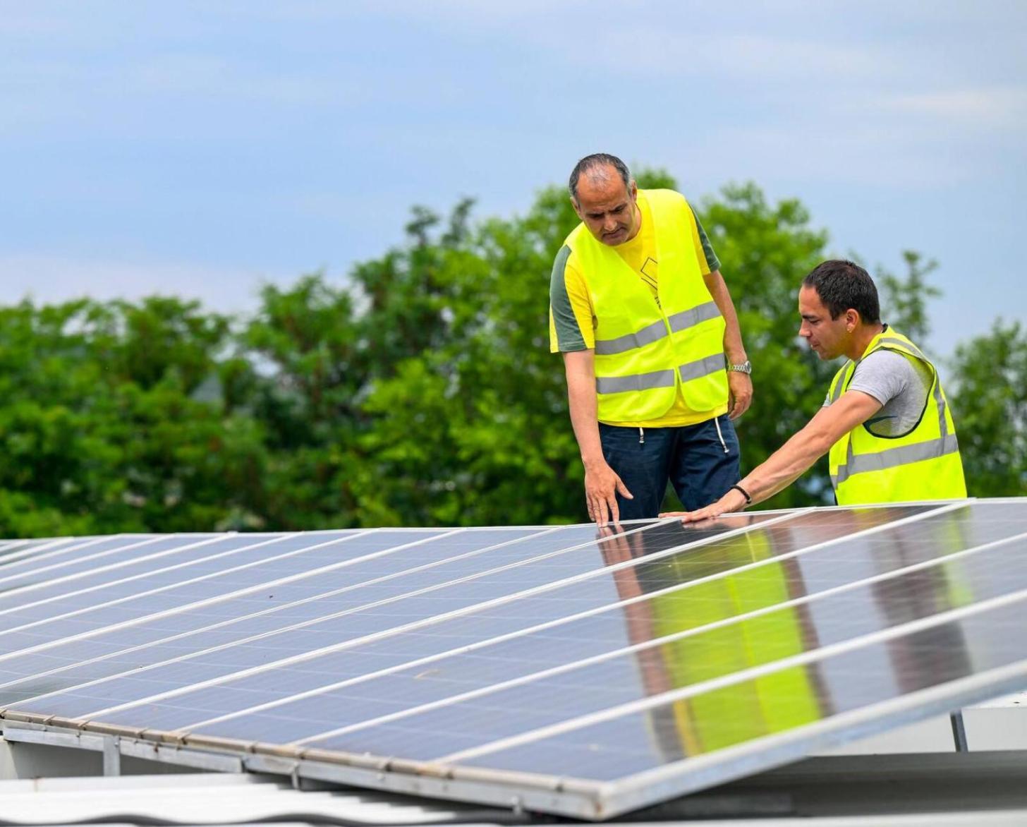 Two men are looking at a solar panel