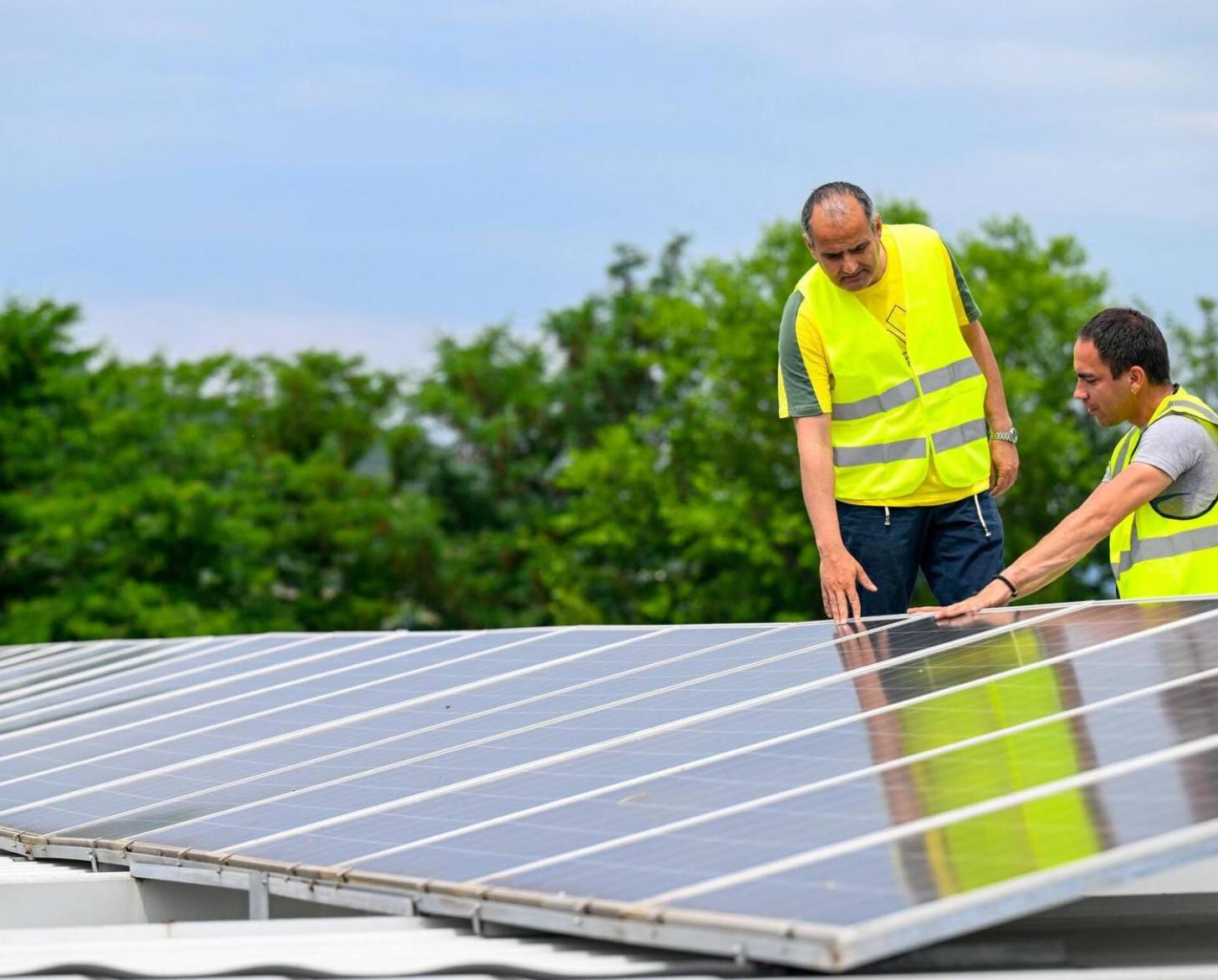 Two men are looking at a solar panel