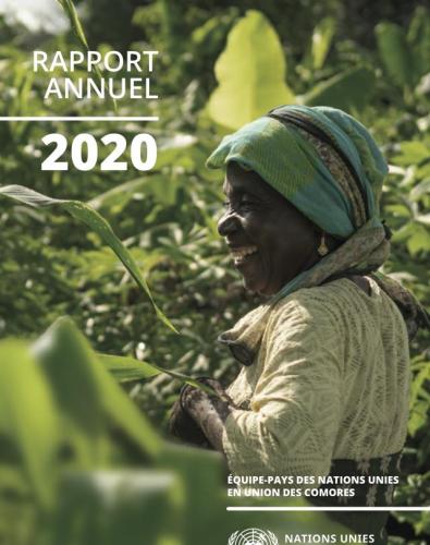 Une femme se tient au milieu d'un champ agricole verdoyant en arborant un grand sourire.