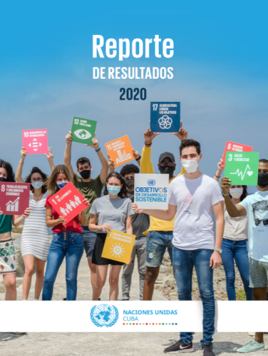 En la playa, un grupo de jóvenes, que usa mascarillas, sostiene carteles con los ODS.