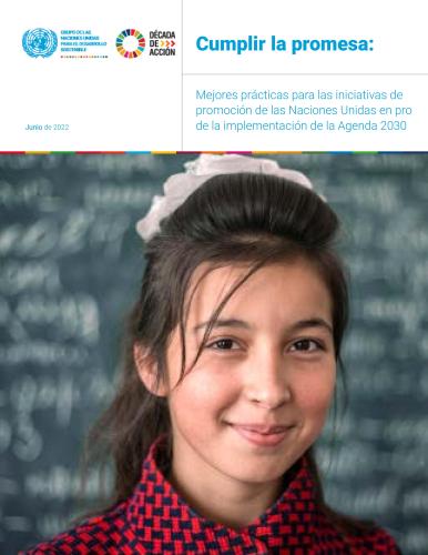 Un primer plano de una chica sonriendo a la cámara frente a una pizarra escrita.