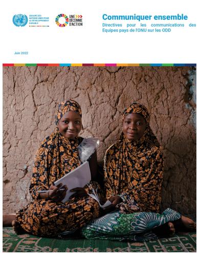 Deux filles qui sDeux jeunes filles de couleur portant un hidjab de couleur noire et jaune sont assies sur un tapis vert, adossées à un mur décrépi, dans une pièce sombre, tiennent chacune un cahier entre les mains et regardent l'objectif en souriant.ourient, sont assises sur le sol contre un mur et se tiennent des dossiers.