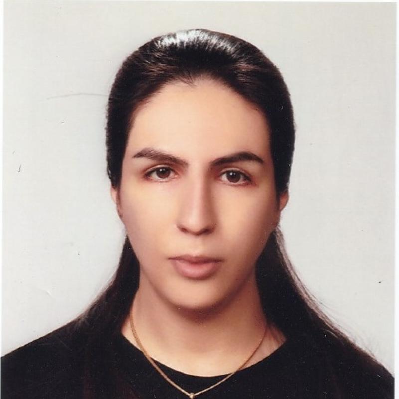 Una mujer de pelo castaño y camisa negra mira directamente a la cámara.