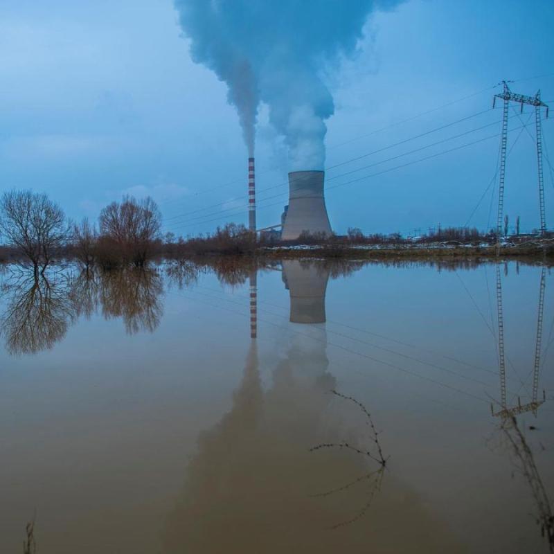 Flooded streets near a factory at sunset. 